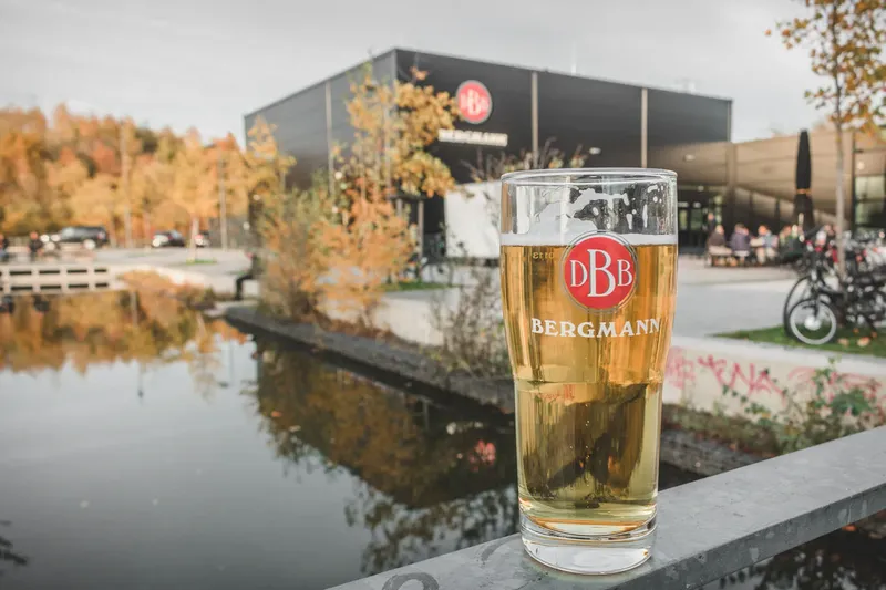 Entdecken Sie die Bergmann Brauerei in Dortmund - traditionelle Braukunst trifft moderne Architektur. Genießen Sie frisch gezapftes Bergmann Bier in authentischer Atmosphäre am Wasser mit herbstlichem Ambiente.
