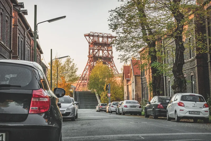 Historische Zeche Consolidation in Gelsenkirchen: Imposanter Förderturm im Herbstlicht, umgeben von charakteristischen Backsteingebäuden und urbaner Wohnbebauung. Ein eindrucksvolles Zeugnis der Ruhrgebiets-Industriekultur.
