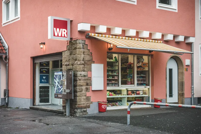 Kiosk in zentraler Lage - Nahversorger mit breitem Sortiment an Süßigkeiten, Getränken und Tabakwaren. Besuchen Sie uns in unserer modernen Filiale mit historischer Steinmauer.
